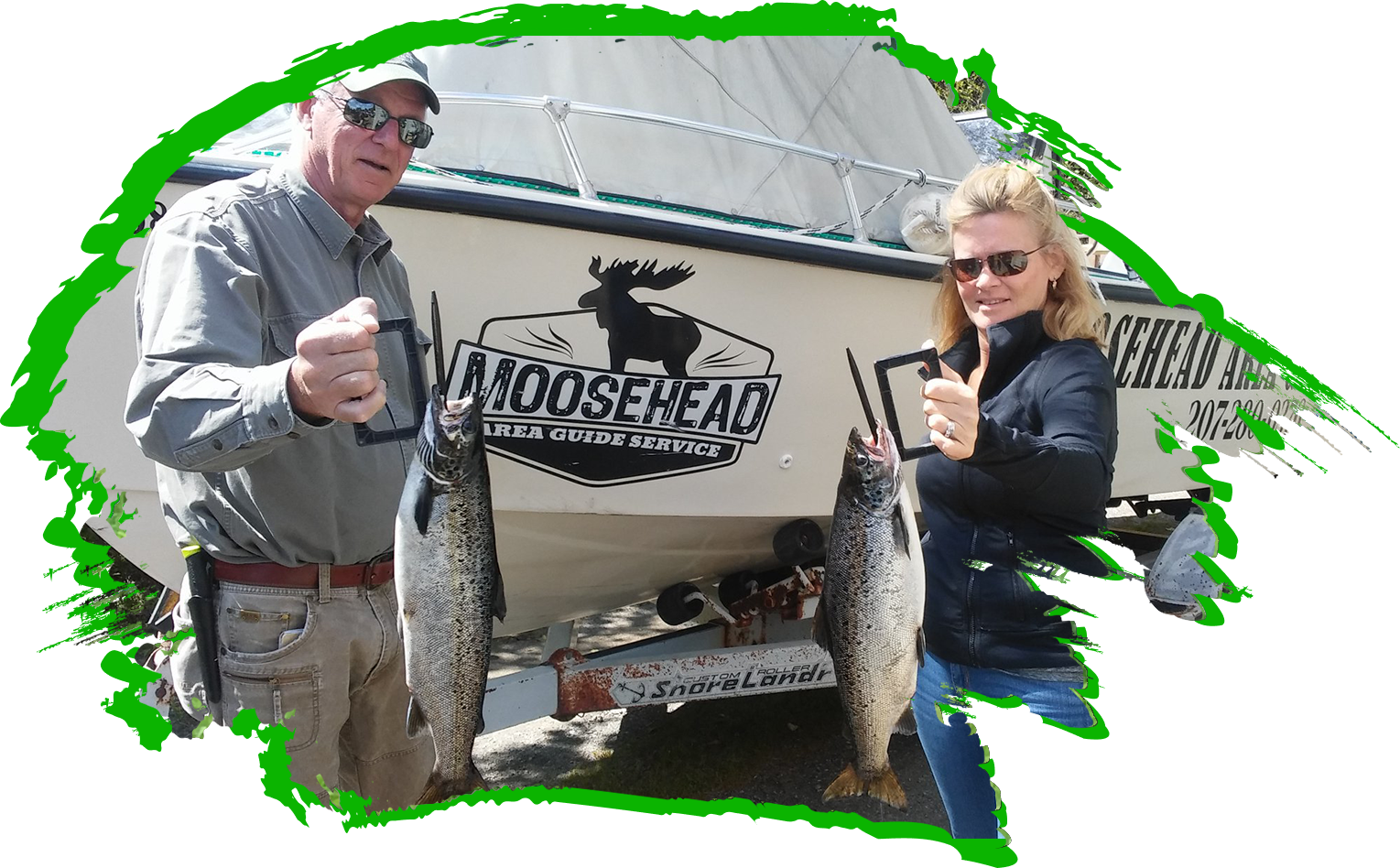 Two people holding fish in front of a boat.