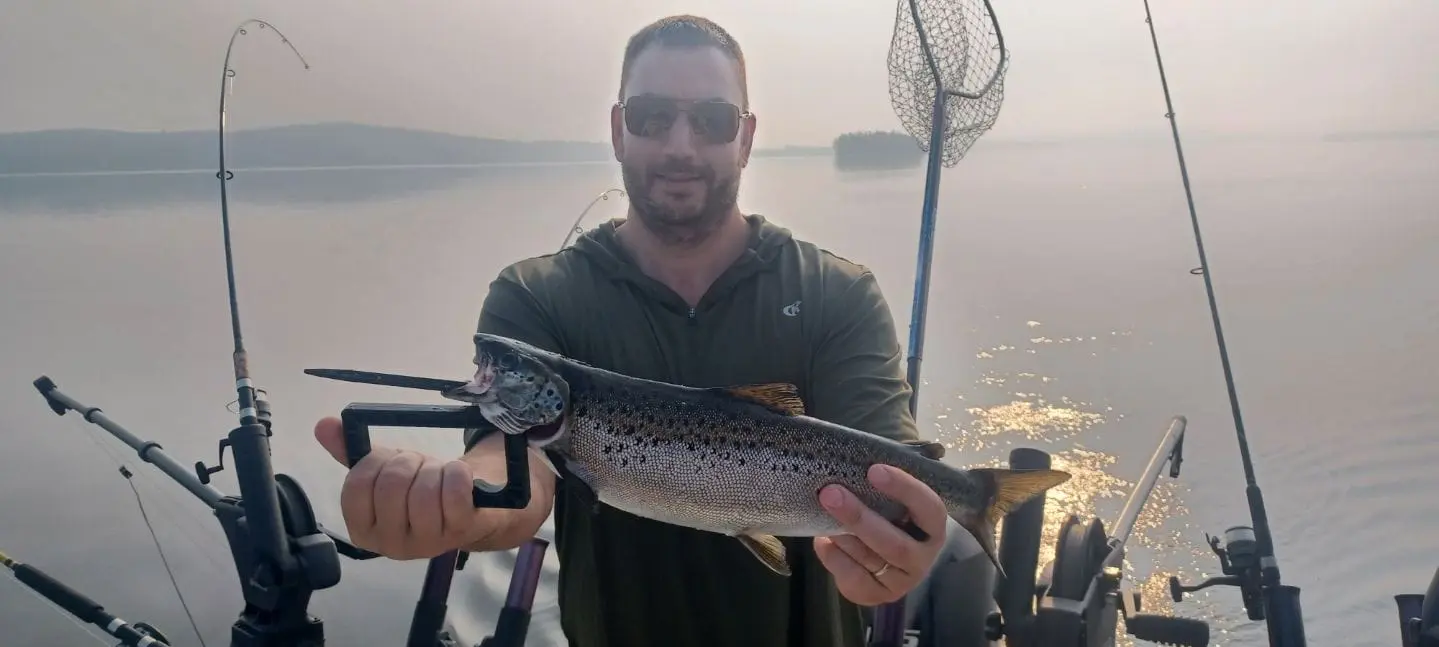 A man holding a fish while standing on top of a building.